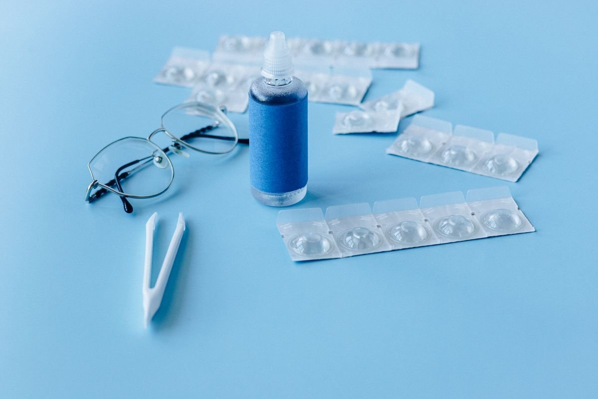 Solución para lentes de contacto y accesorios de cuidado ocular sobre fondo azul