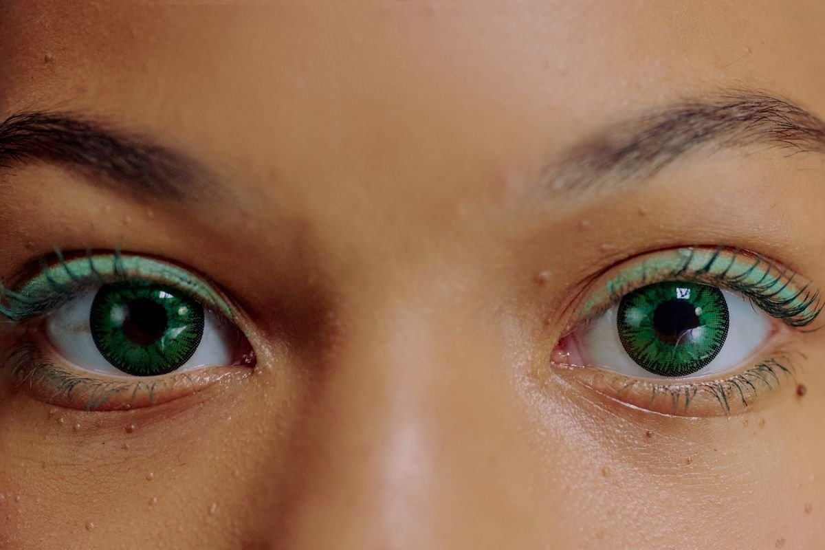 Primer plano de persona con lentes de contacto de color sobre ojos oscuros