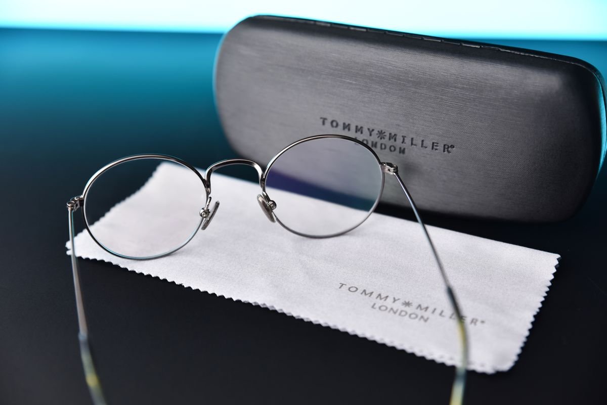 Lentes junto a su estuche y un paño de microfibra sobre una superficie oscura