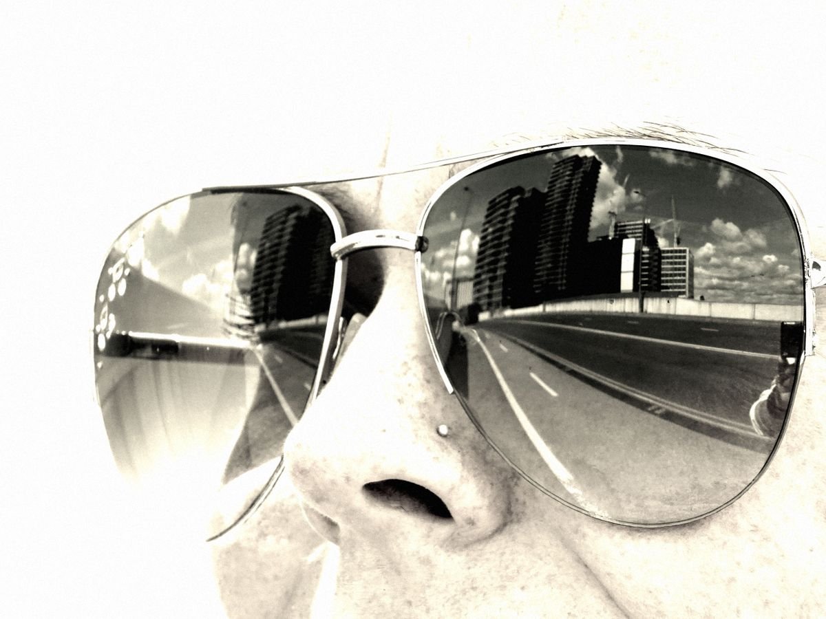 Persona con lentes de sol reflejando la luz del día