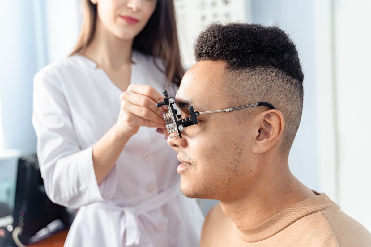 Hombre con montura de prueba durante un test de visión en clínica