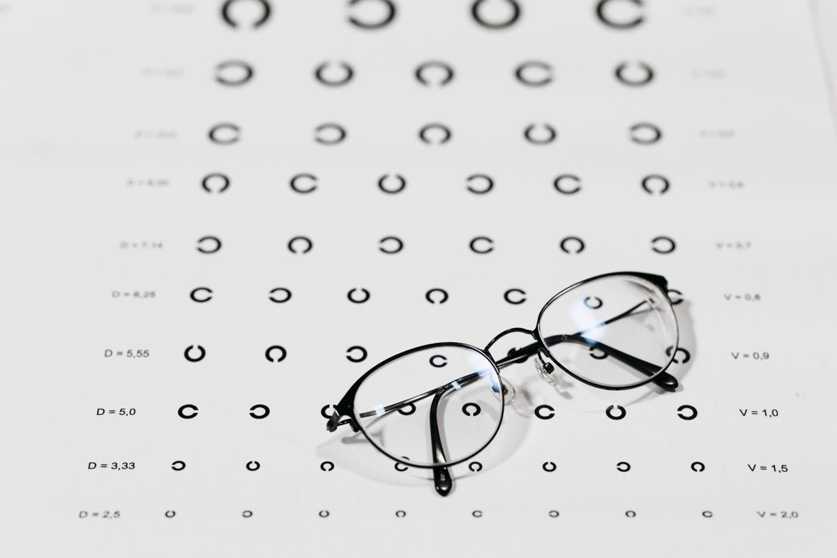 Lentes graduados apoyados sobre una tabla de medición optométrica en una óptica